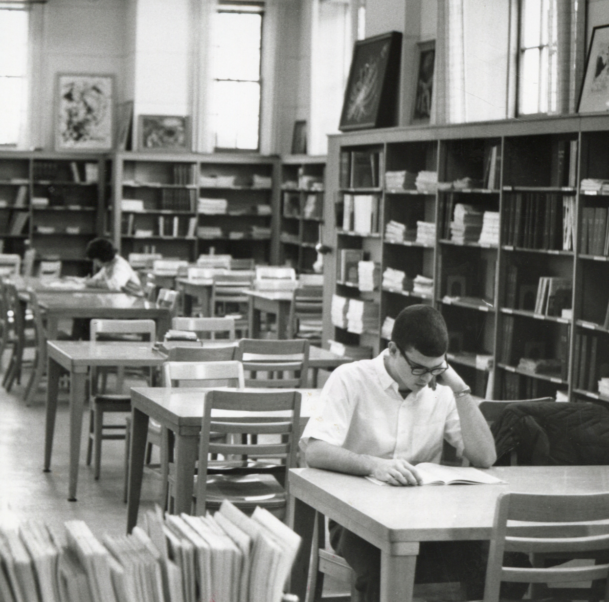 A student studies at a table in the library.
