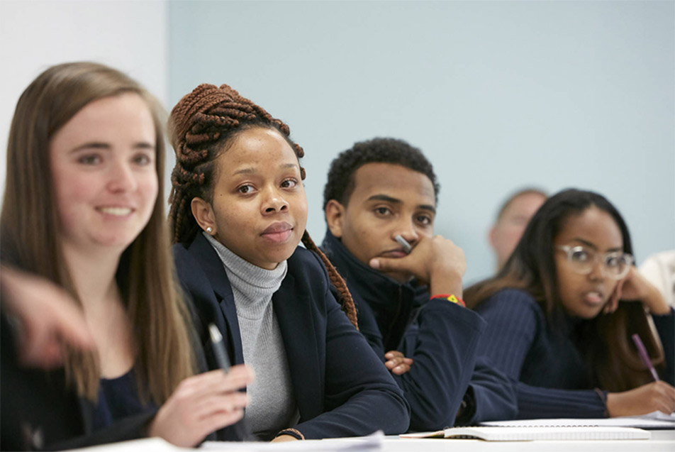 Photo of four students sitting at a desk