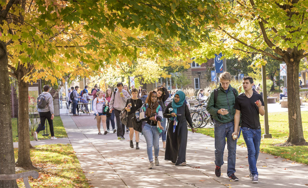 Photo of students walking around Macalester campus on a sunny fall day.