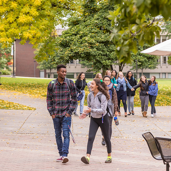 Students walking on campus in autumn.