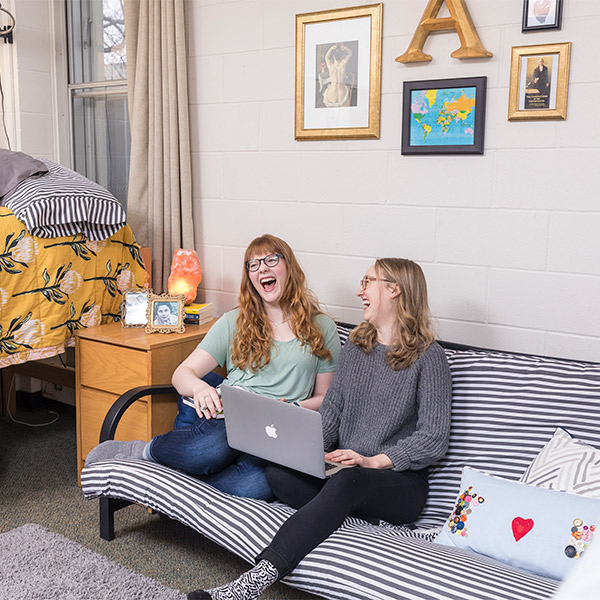 Two students in a residence hall room.