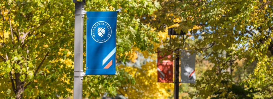 Banners affixed to light posts on the Macalester campus in autumn.