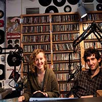 Photo of two students smiling in the Macalester radio station.