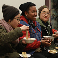 Photo of three students eating soup and talking