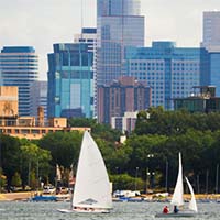 Photo of boats in Bde Maka Ska against the Minneapolis skyline