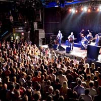 Photo of a crowd of people listening to a band play at First Ave.