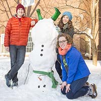 Photo of three students posing with an upside-down snowman