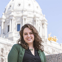 Photo of a student standing in front of the Capitol