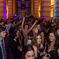 Photo of a crowd of students in formal wear dancing and talking