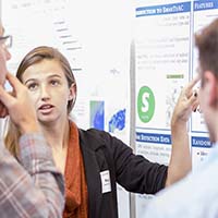 Photo of a student presenting a research poster