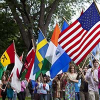 Photo of a line of students carrying flags representing their home countries