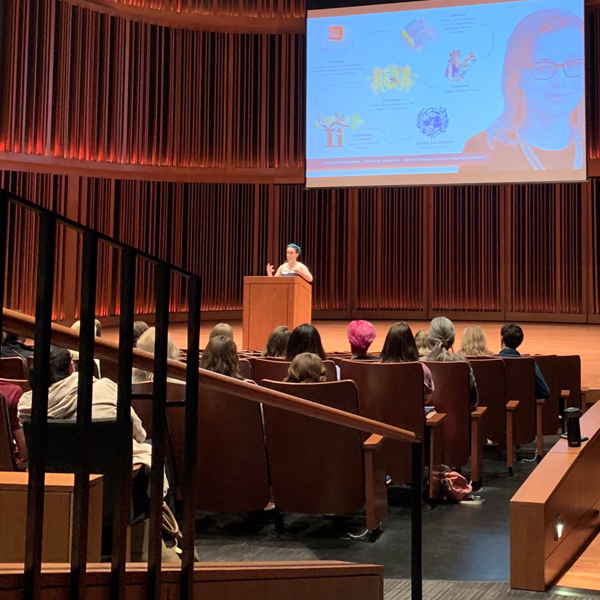 An admissions counselor addressing prospective students in the Mairs Concert Hall.