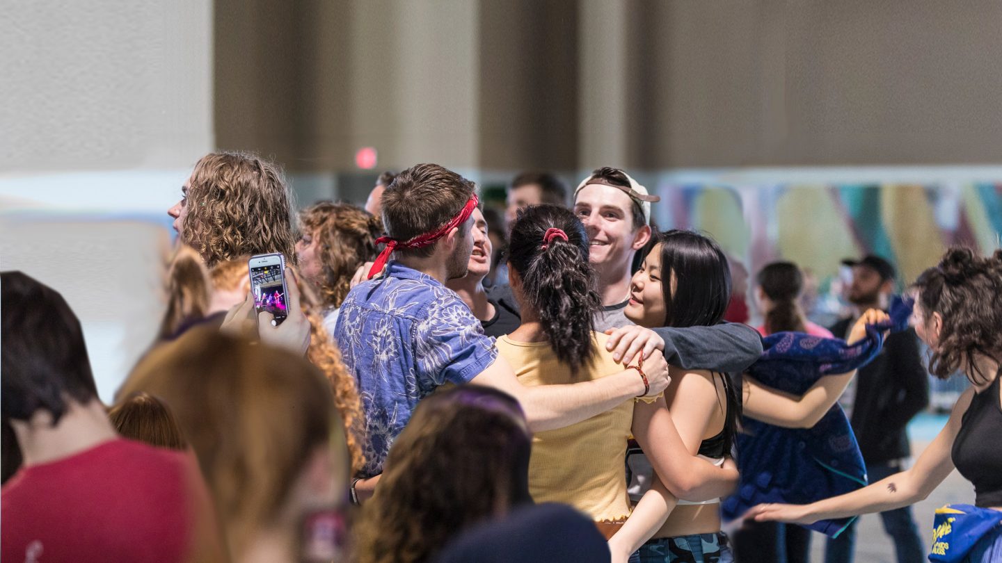 A group of five students hugs during a concert at Macalester.