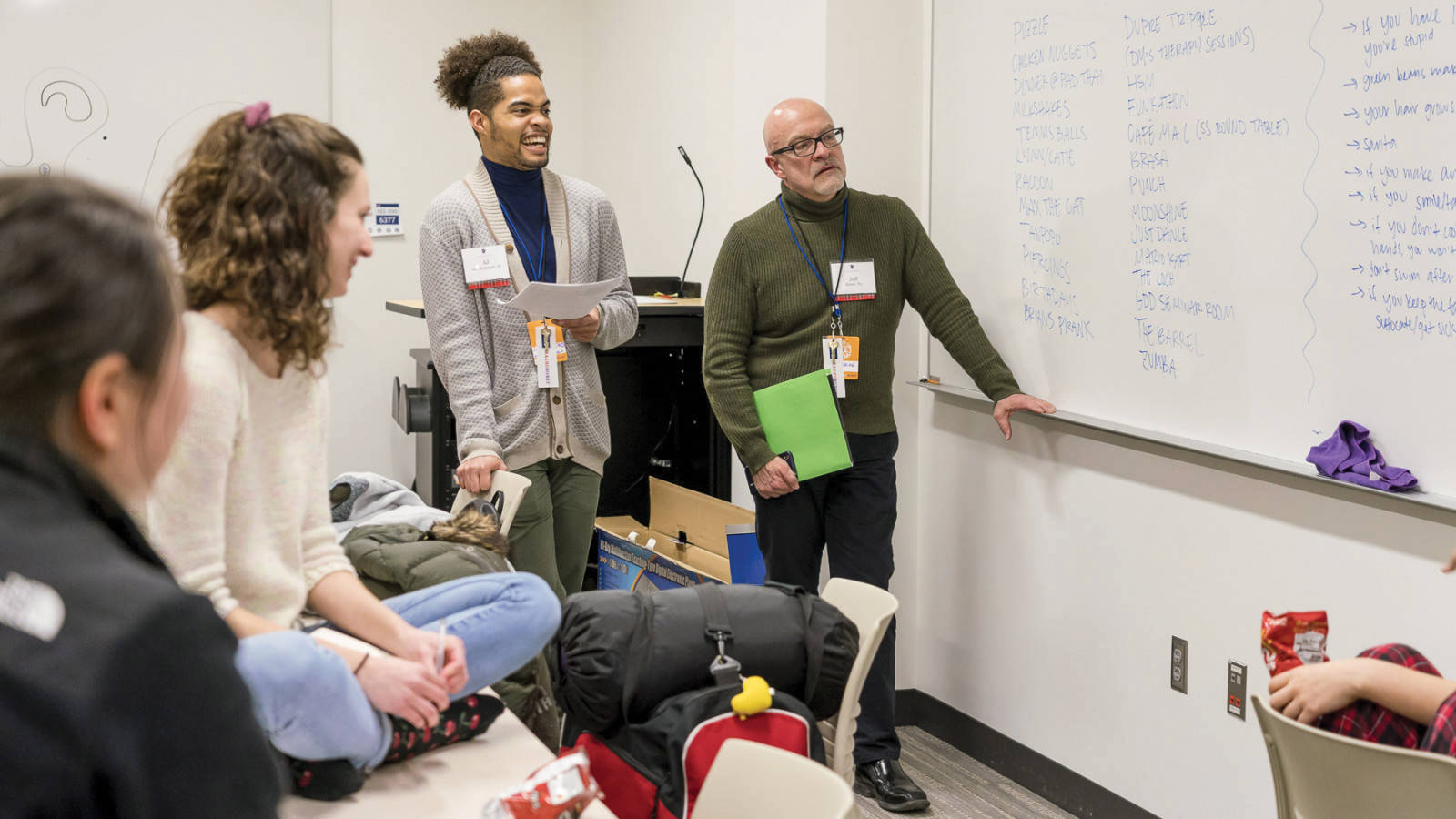 Alumnus and students stand in front of a whiteboard