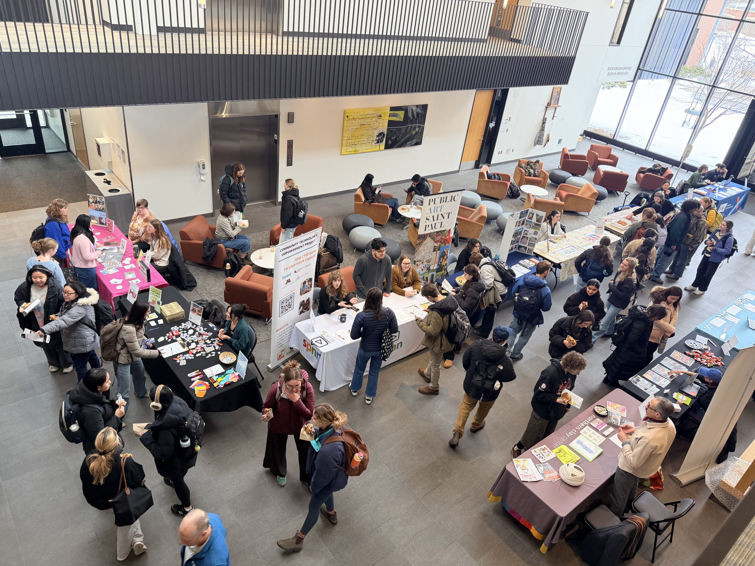 A view from above of employers tabling in Art Commons. Students speak with representatives at each table.