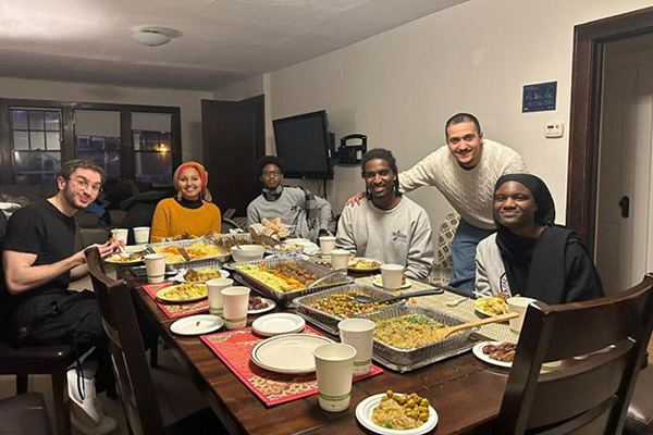 Arabic House residents sit around a table full of food for iftar