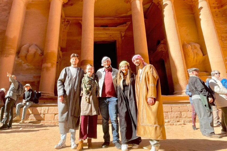 Five students stand in front of a temple in Petra, Jordan