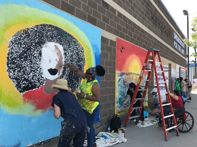 Community members paint murals on University Ave