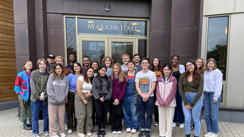 Group of students standing in front of Markim Hall and smiling