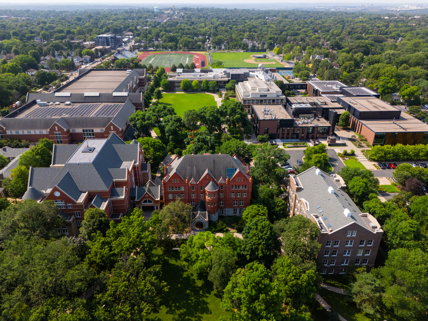 Drone view of Macalester College's campus, including Carnegie Hall, Old Main, the DeWitt Wallace Library, the Leonard Center, Janet Wallace Fine Arts Center, the Olin-Rice Science Center, the Humanities building, and the athletic fields of the campus.