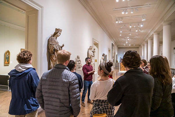 Art History students gather around a statue at Minneapolis Institute of Art