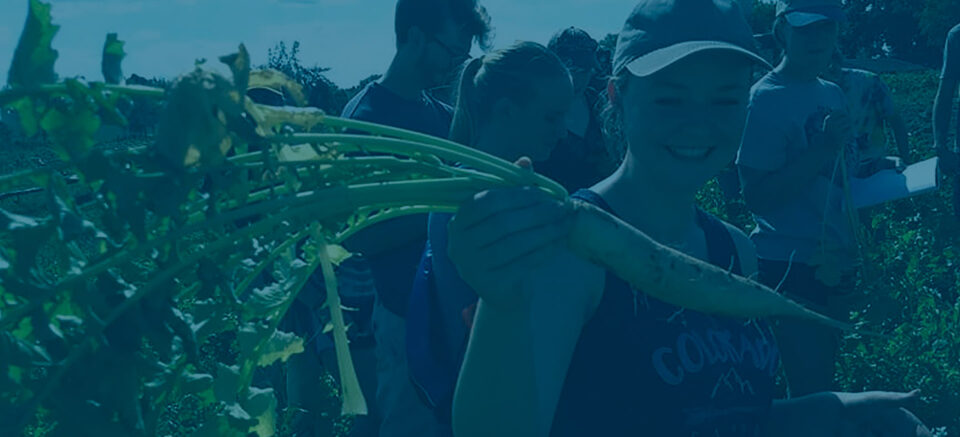 Student holding a carrot and smiling