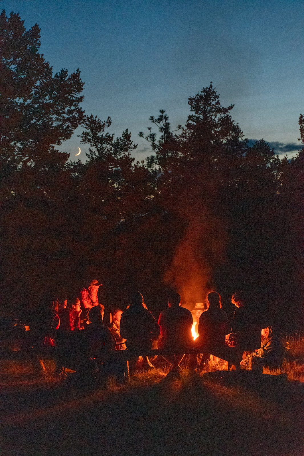 Geology students sitting around a campfire while on a field research trip.