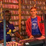 Matthew Wilkinson sitting at a radio booth at Voices in the Wilderness radio station