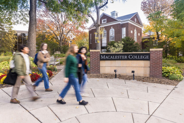 Four people walking in front of Macalester college