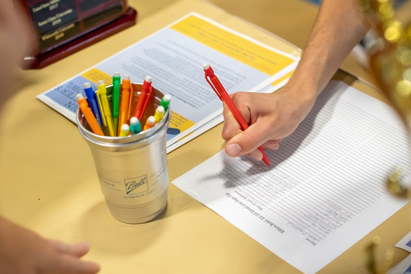 Close-up of a student's hand signing up for a student organization