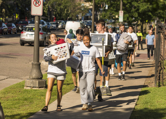 Students carrying boxes on new student move-in day