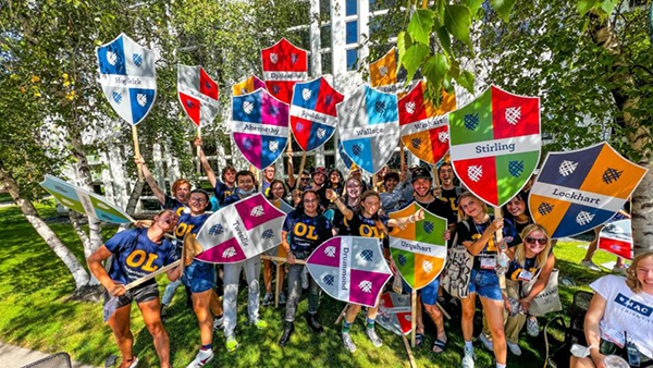 Group of students holding large signs with crests at Orientation