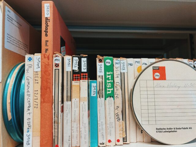 Archives shelf packed with audio and film reels, spines facing out.