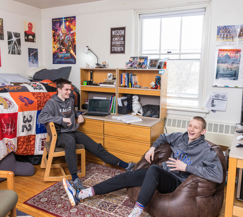 Two students in a residence hall room.