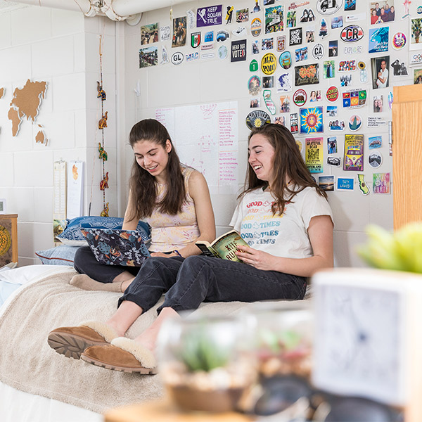 Two students in a residence hall room.