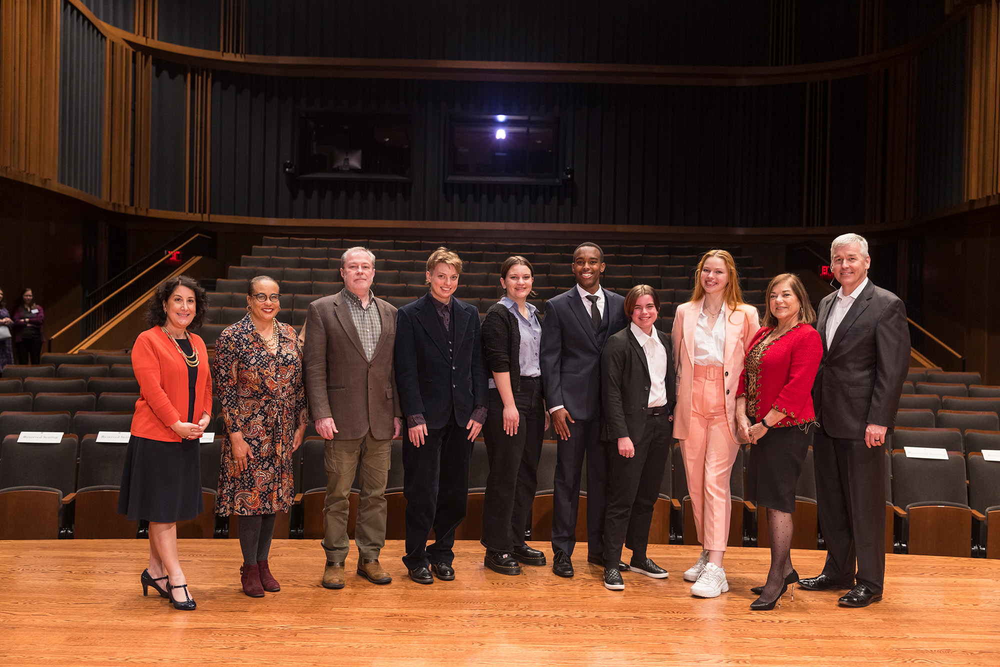 Congress to Campus participants, including students, faculty, and President Rivera, pose with former US representatives on stage in Mairs Concert Hall.