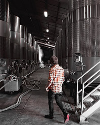 Justin Lee '08 amid the large-scale barrels of one of the dozen wineries owned by Kendall Jackson.