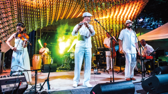 Doug Little '91 plays flute on stage with the rest of the members of his band, Charanga Tropical