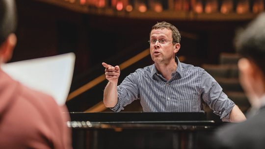 Photo of Michael McGaghie directing a choir