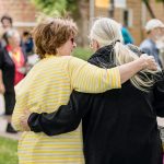 Two alumni embrace each other
