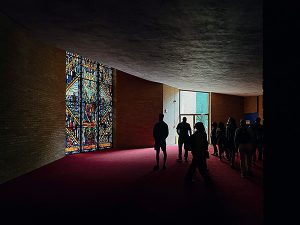 Group inside church looking at stained glass window