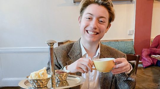 Julian Applebaum smiling and holding a teacup