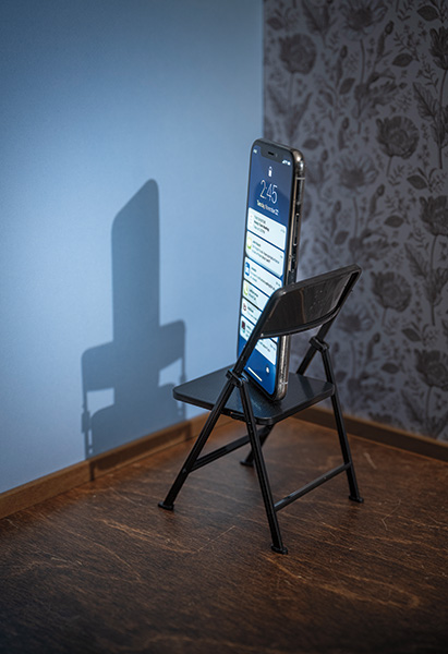 Illustration of a phone sitting in a chair in a corner