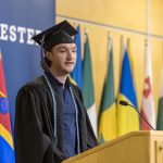 A graduating student speaks at the podium at Macalester's 2022 December graduation ceremony.