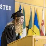 A graduating student speaks at the podium during Macalester's 2022 December Graduation.