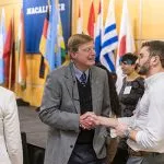 Phil Geier shakes hands with a student