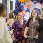 Five people converse and laugh in Kagin Commons during the Hall of Fame dinner