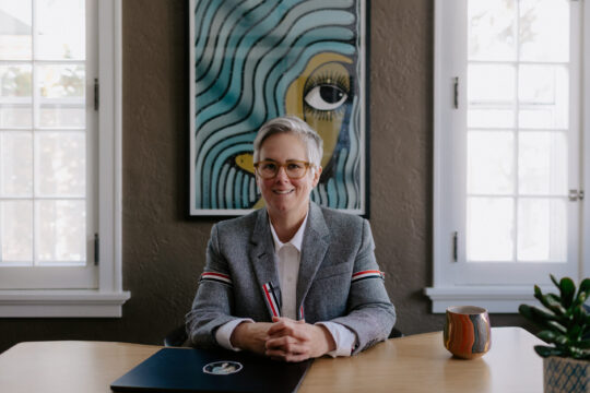 Erin DeRuggiero ’96 poses for a photo in their office.