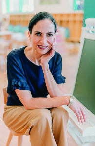Carola Stead de Fallon ’94 smiles while seated outdoors, reflecting on the global community built through Macalester.
