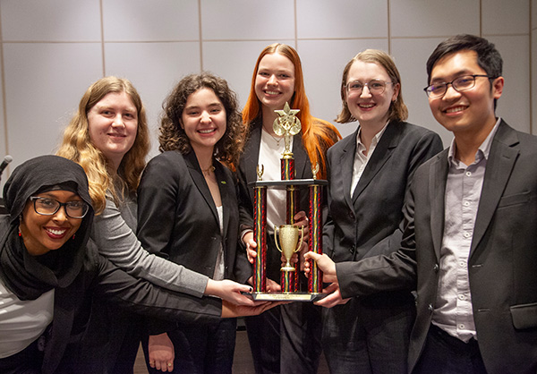 Six Macalester Ethics Bowl team members hold a trophy